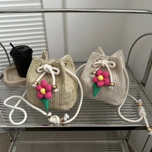 Sweet straw bucket bag for summer with hand-woven texture and cute flower charm