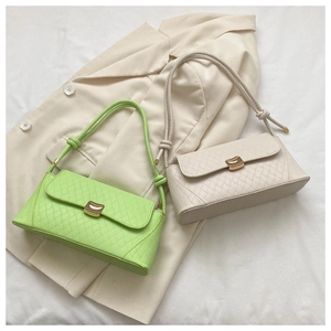 Détail du motif matelassé et boucle dorée sur les sacs à bandoulière beige et vert