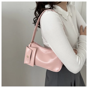 Detail of light pink shoulder bag with a matching small coin pouch and gold hardware accents