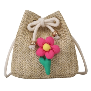 Handmade straw bucket bag with large pink floral decoration and drawstring closure