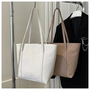 Dettagli di borse tote trapuntate a chevron in ecopelle bianca e beige con manici lunghi
