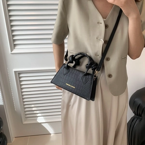 Petit sac carré noir à motif crocodile, poignée torsadée et bandoulière amovible