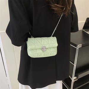 Quilted mint green crossbody bag with silver chain strap and metal lock closure