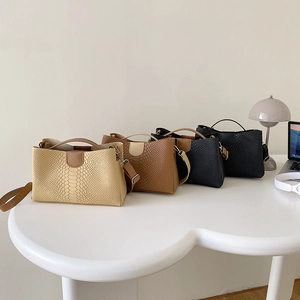 Minimalist faux crocodile leather tote bags in four colors on a white office desk