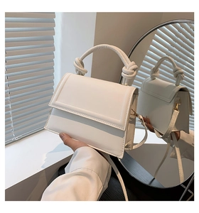 Détail du sac bandoulière blanc avec poignée à nœud torsadé et cuir PU lisse de qualité
