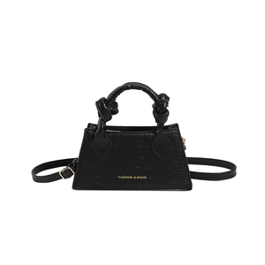 Sac à main noir en cuir de crocodile avec poignée à nœud et lettrage doré élégant