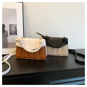 Detail of color-block PU leather handbags featuring quilted texture and knotted handles