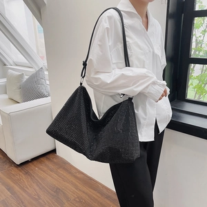Chic black rhinestone hobo bag with adjustable strap shown on model in a modern room