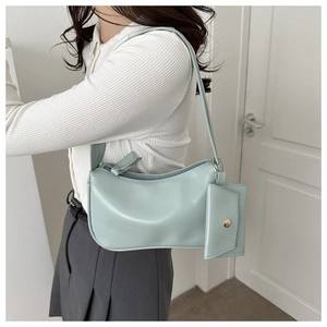 Detail of mint green hobo bag with matching coin purse charm worn on shoulder
