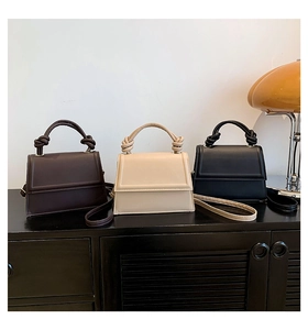 Trois sacs bandoulière minimalistes en cuir marron, beige et noir avec poignées nouées