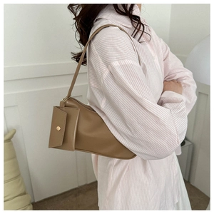 Close-up of khaki PU leather shoulder bag featuring an asymmetric design and golden buckle