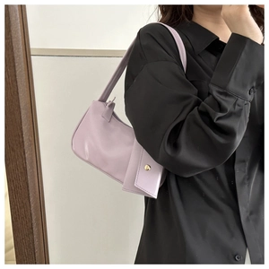 Lavender faux leather shoulder bag with matching mini pouch accessory on a model