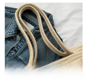 Détail des poignées en corde épaisse d'un sac cabas en paille tissée beige