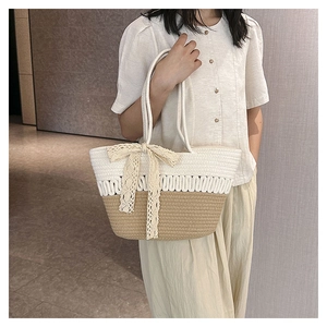 Detail of summer woven tote bag featuring a beige lace bow and contrasting textures
