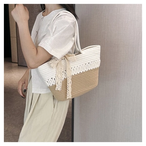 Detail of two-tone woven tote bag featuring a delicate lace bow and cotton rope texture