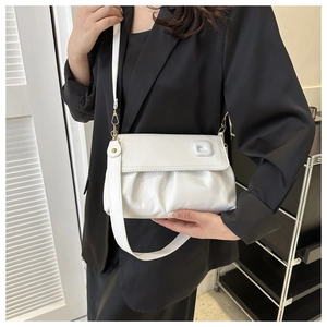Détail du sac nuage blanc plissé avec boucle carrée porté par un mannequin en noir
