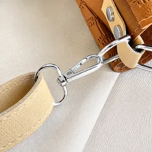 Macro detail of silver metal hook and premium crocodile pattern brown leather strap