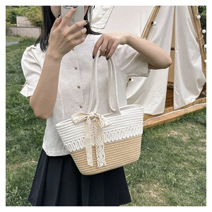 Close-up of dual-tone woven tote bag with white lace bow and sturdy rope handles