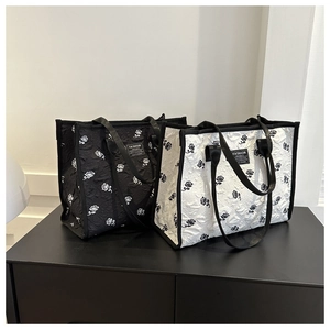 Detail of black and white tote bags with 3D rose floral quilting and leather fashion label