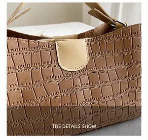 Close-up of brown crocodile texture leather tote bag with fine stitching details