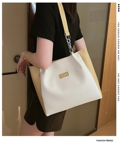 Détail du grand sac cabas tendance avec couleurs contrastées et chaîne argentée de l'épaule