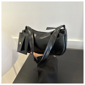 Detail of black faux leather crescent shoulder bag with matching mini pouch attachment