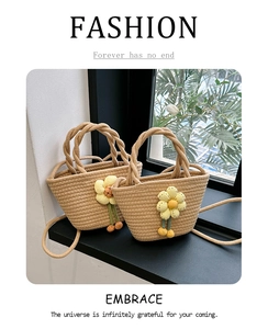 Detail of straw woven tote bag with yellow crochet flower charm on a windowsill