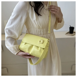 Détail du sac à bandoulière jaune plissé avec boucles dorées et bandoulière réglable chic