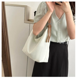 Detail of white large capacity oxford hobo bag with brown adjustable leather strap