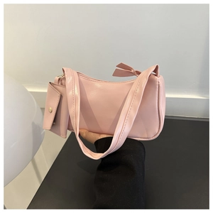 Detail of pink crescent underarm bag featuring a matching mini coin purse and zipper closure