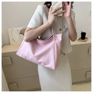 Macaron pink large capacity tote bag shown on model in a minimalist lifestyle setting
