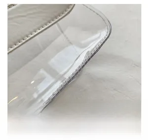 Détails des coutures en cuir blanc et du matériau PVC transparent sur le sac bandoulière