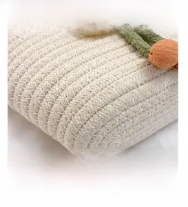 Detailed macro view of woven cream cotton rope bag with green stems and orange floral decor