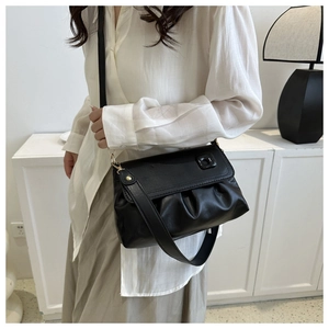 Gros plan d'un sac à bandoulière noir plissé élégant avec une texture en similicuir souple