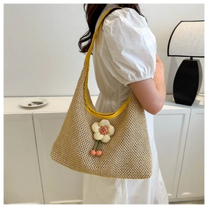 Detalle del bolso de paja con flor de tela y colgante de cereza para el verano