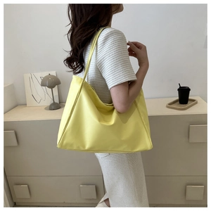 Bright yellow large capacity tote bag shown on model with minimalist leather texture