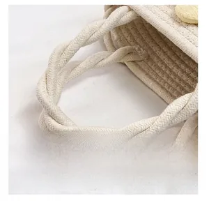 Detail of twisted rope handle and straw weave texture on a beige summer bucket bag