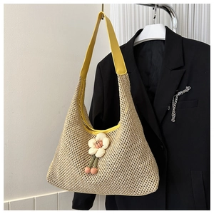 Détail du sac cabas en paille avec bandoulières en cuir jaune et fleurs décoratives