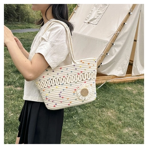 Detail of hand-woven straw tote with colorful polka dots and daisy floral charm