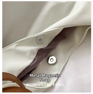 Close-up of Oxford tote bag magnetic closure with silver hardware and brown lining