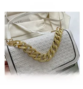 Detailed view of the white crossbody bag with woven texture and gold chain strap