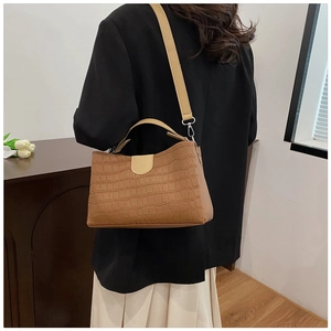 Detail view of crocodile pattern tote bag in caramel brown with detachable shoulder strap