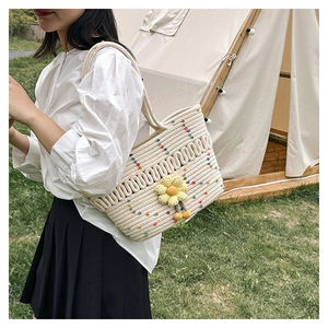 Detail of crochet tote bag with colorful dots and a yellow knit sunflower charm