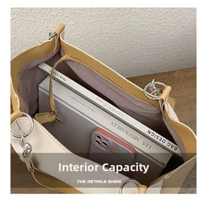 Intérieur spacieux du sac cabas bicolore montrant les poches et la capacité pour livres