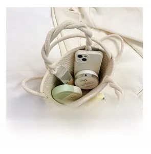 Top view showing the internal capacity of the woven straw bucket bag with daily essentials