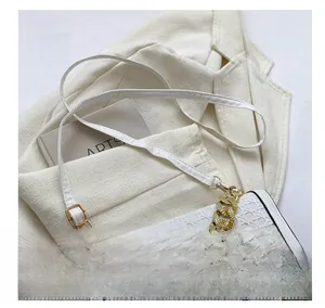 Detailed view of white woven texture synthetic leather bag with gold chain and strap