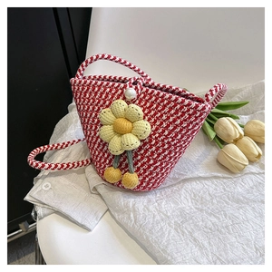 Detail of red and white knit bucket bag with large yellow flower and pearl closure