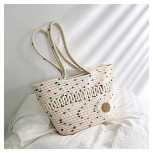 Close-up of hollow cotton weave texture with colorful dots and a white daisy charm