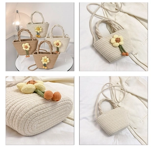 Detail of handmade woven cotton straw bucket bag with floral accents and tassel pendant