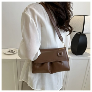 Détail du sac à bandoulière marron foncé plissé avec rabat et boucle carrée élégante